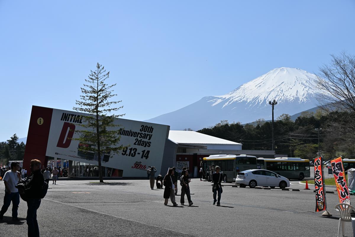 澄み渡る青空の下、富士山を背景に設置された「頭文字D」30周年記念の看板とイベント会場の様子