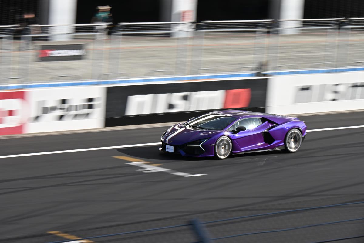 鮮やかな紫色のボディが映える、サーキットを高速走行するランボルギーニの躍動的なショット