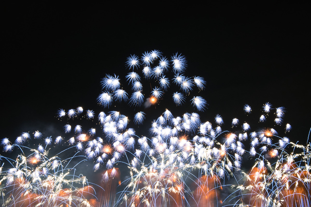 雪の結晶のように白く細かな火花が無数に広がり、幻想的な幾何学模様を描く花火