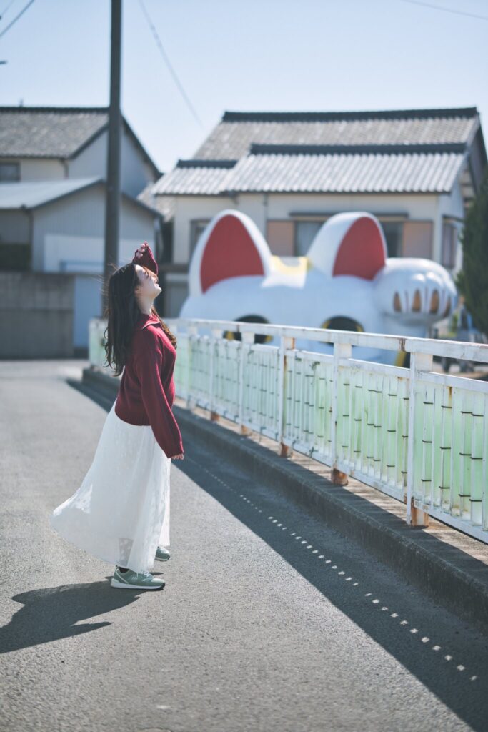 常滑市の遊歩道で、とこにゃんを背に全身と表情を捉えた花咲ゆいなさんの写真