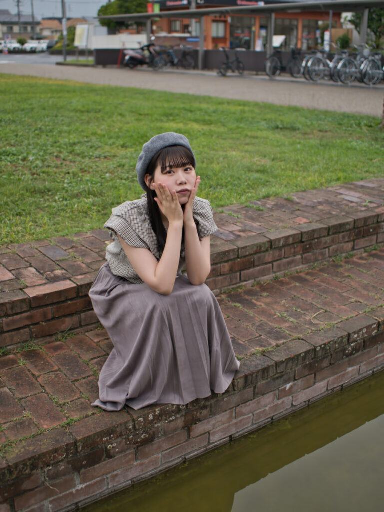 半田赤レンガ建物の中庭で、雨に濡れたウッドデッキの上に立つゆめのさんの全身ショット。換算40mmの画角が、場所の空気感と人物を調和させる。