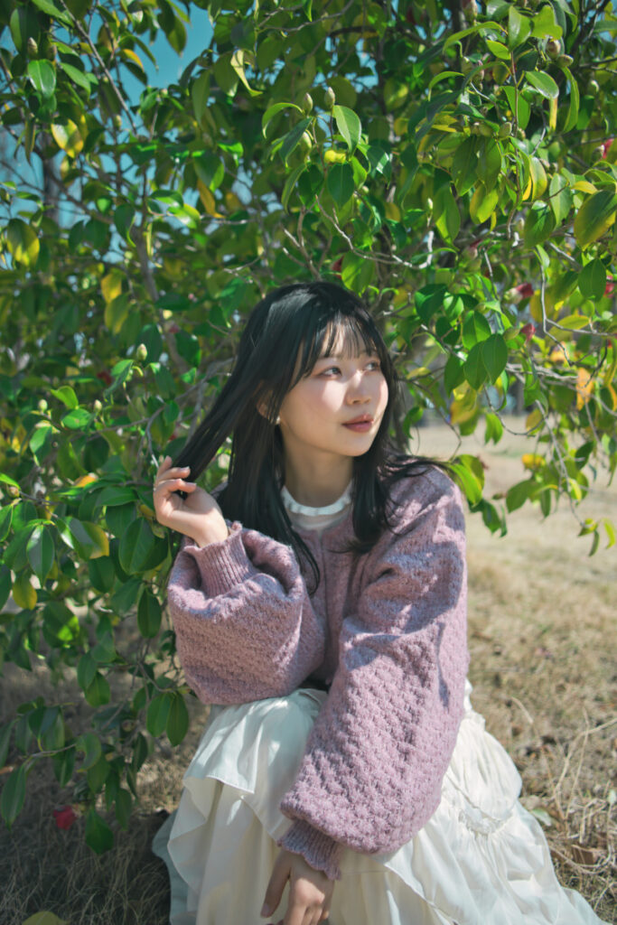 ツバキを背に、ぬぬさんの後ろ姿をシルエットで捉えたドラマチックな一枚。