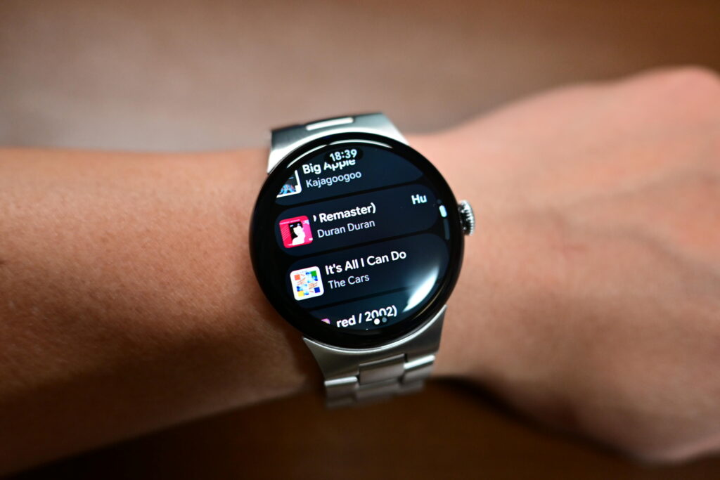 腕に装着したPixel Watch 4の鮮明なディスプレイと、YouTube Musicの操作画面