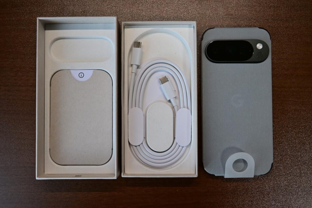 漆黒のデスクに平置きされたPixel 10 Pro（Obsidian）の付属品。