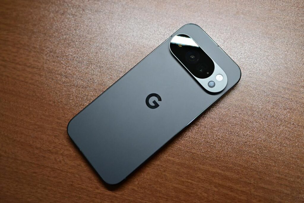 漆黒のデスクに平置きされたPixel 10 Pro（Obsidian）の背面。特徴的な水平のカメラバーと3つのレンズ、Googleの「G」ロゴが質感高く写るカット。