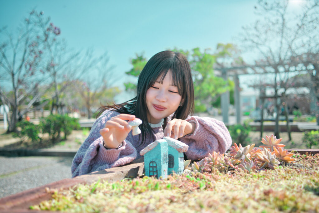 多肉植物のグリーンと、メルヘンな小さな家に囲まれ、遊ぶぬぬさん。