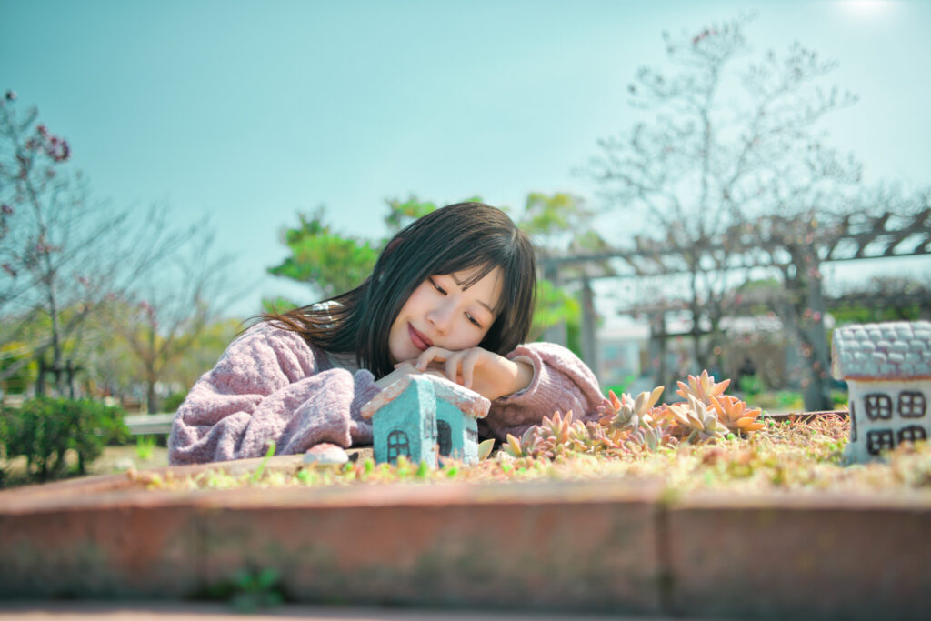 多肉植物のグリーンと、メルヘンな小さな家に囲まれ、遊ぶぬぬさん。