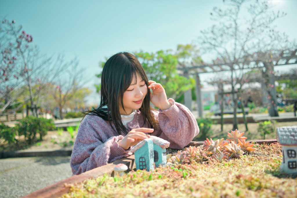 多肉植物のグリーンと、メルヘンな小さな家に囲まれ、遊ぶぬぬさん。