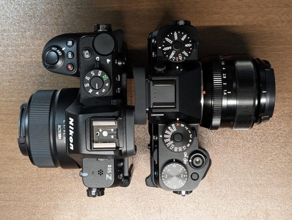上面から比較したNikon Z50IIとFUJIFILM X-T5。モードダイヤルがあるZ50IIに対し、物理ダイヤルのみが並ぶX-T5の操作系の違い。