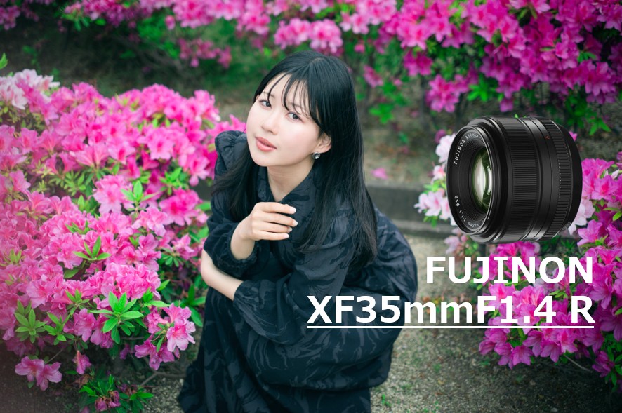 フジノンレンズ XF35mmF1.4 Rで撮影された、鮮やかに咲き誇るツツジに包まれてリラックスした表情を浮かべるモデルのぬぬさんのポートレート写真。