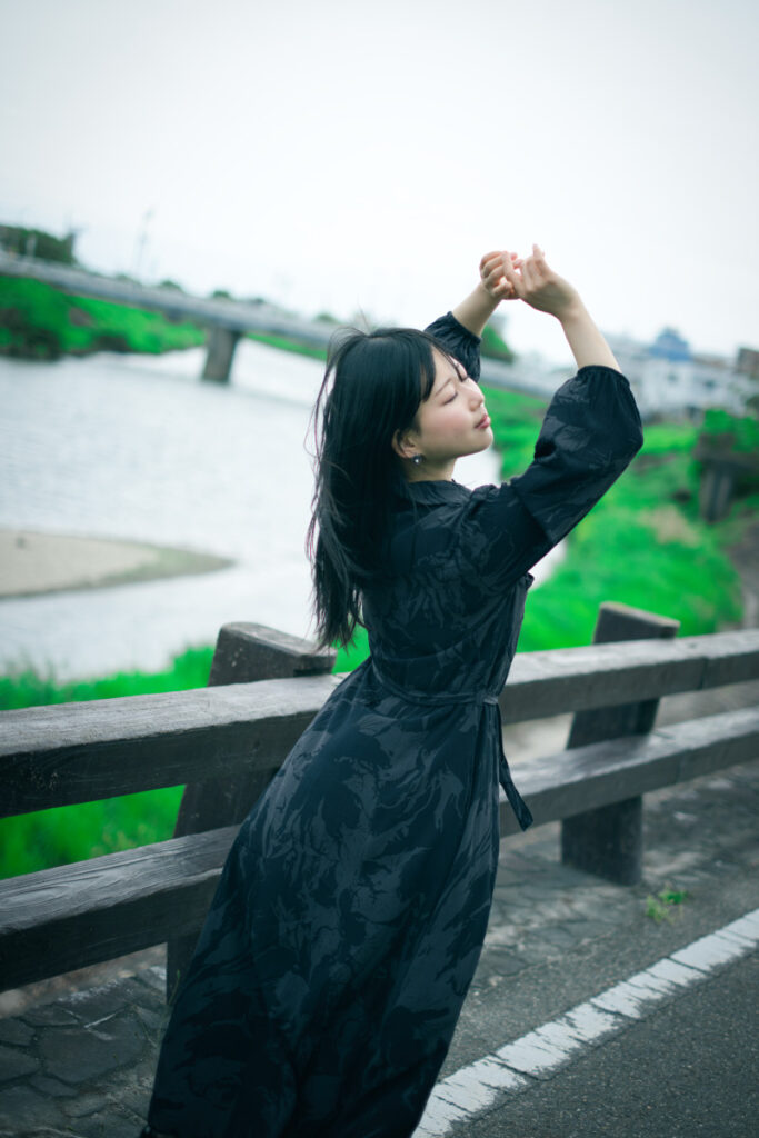 川沿いで、XF35mmF1.4 Rによって背景の情景が滑らかにボケ、被写体のぬぬさんが際立つポートレート。