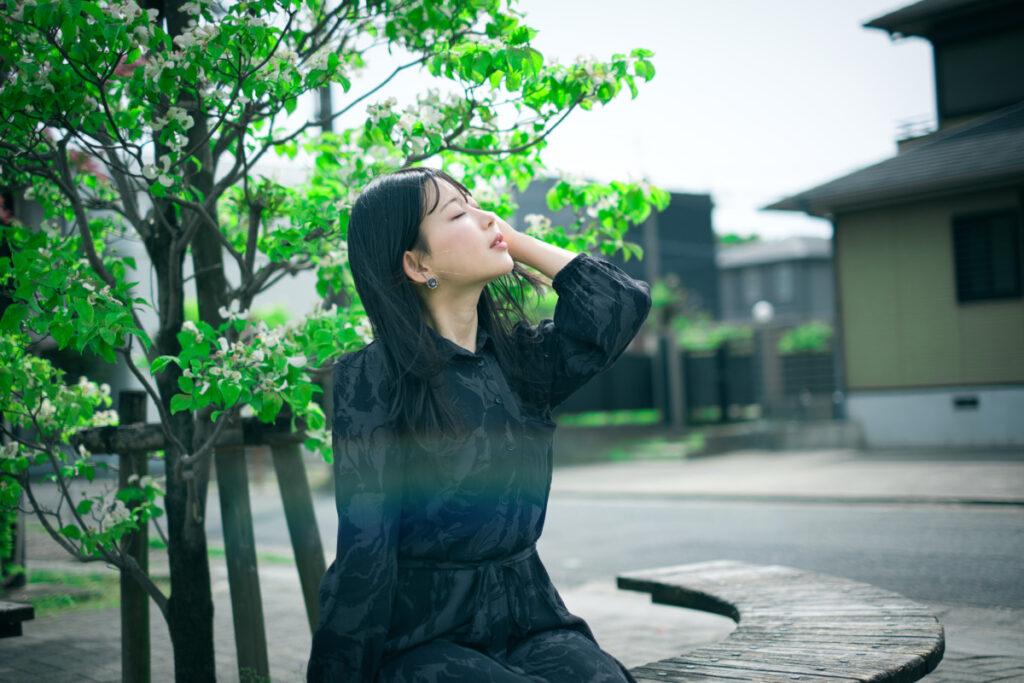 清州城周辺の緑豊かな場所で、木漏れ日が差し込み、XF35mmF1.4 Rによって美しい光の玉ボケが生まれたぬぬさんのポートレート。