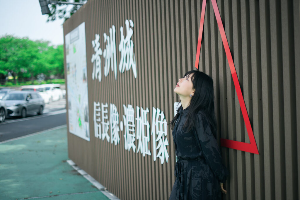 清州城の看板と撮るポートレート。ぬぬさんの表情とXF35mmF1.4 Rによる奥行あるボケみある写真となった。