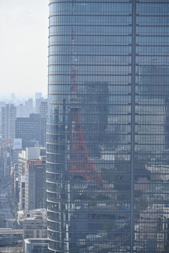 日比谷ミッドタウンのガラス外壁に映り込んだ東京タワーをNikon Z50IIで撮影した写真。