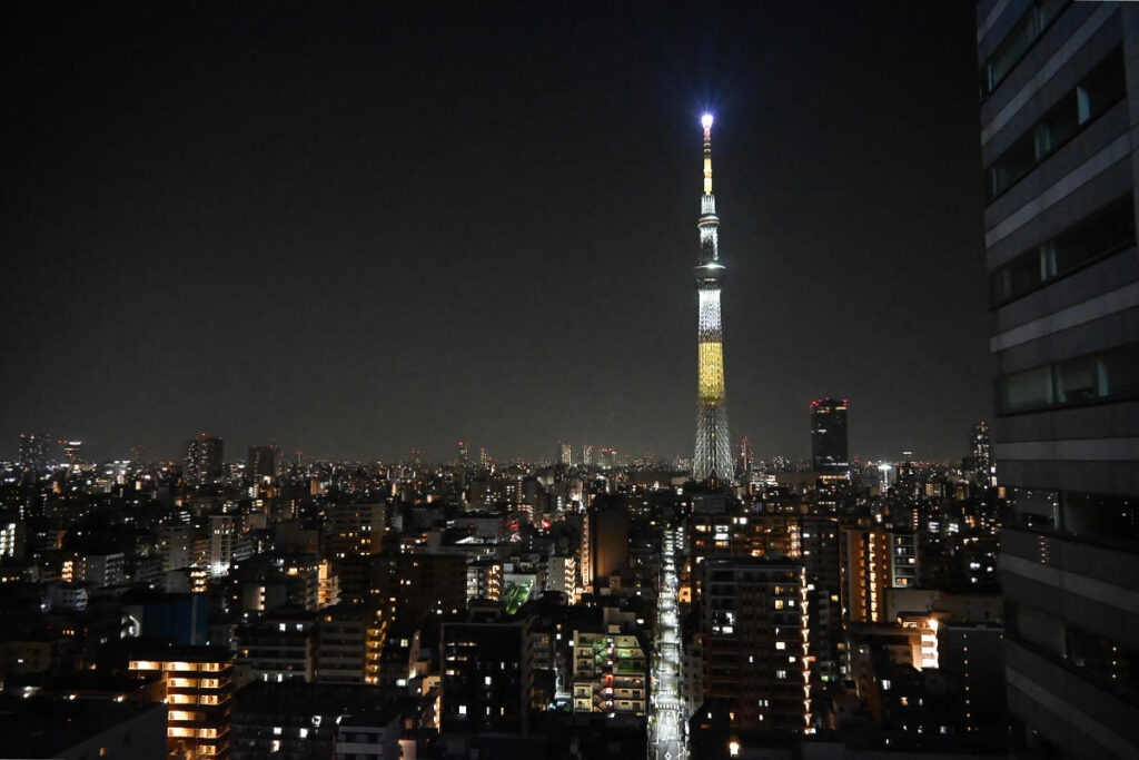 ホテルの部屋の窓から、美しくライトアップされた東京スカイツリー（夜景）をNikon Z50IIで撮影した写真。