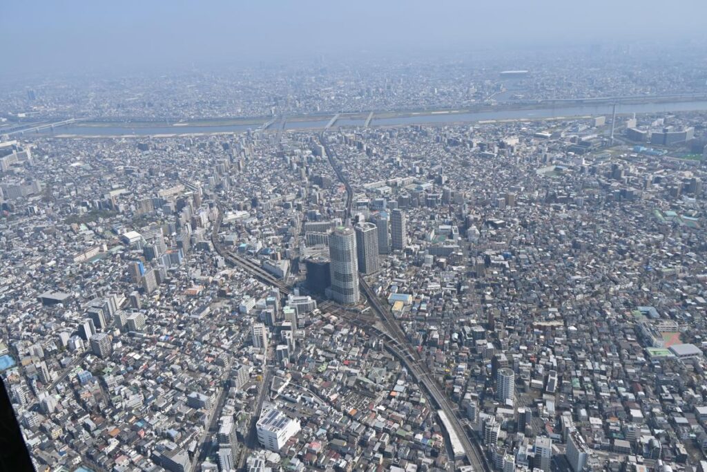 東京スカイツリーの展望台（天望デッキ）の窓から見える、ジオラマのような東京の街並みをNikon Z50IIで撮影した写真。