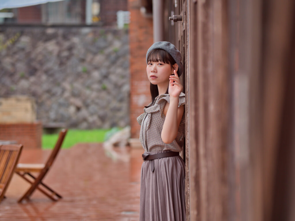 雨の日の静謐な質感を活かしつつ、カラーハーモニー機能で赤レンガの温もりとモデルの肌の血色感をシンクロさせた現像作品