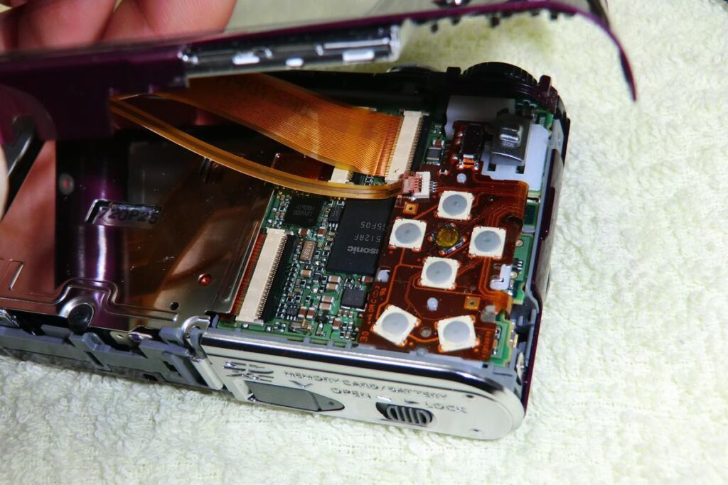 背面カバーを取り外し、基板と液晶パネルを繋ぐリボンケーブルが露出したカメラの内部