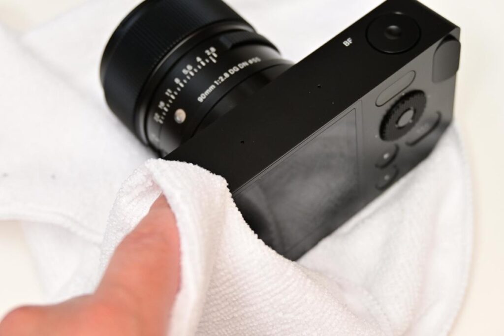 返却前に白いマイクロファイバークロスを使ってSIGMA bfのアルミボディを優しく拭き掃除している様子