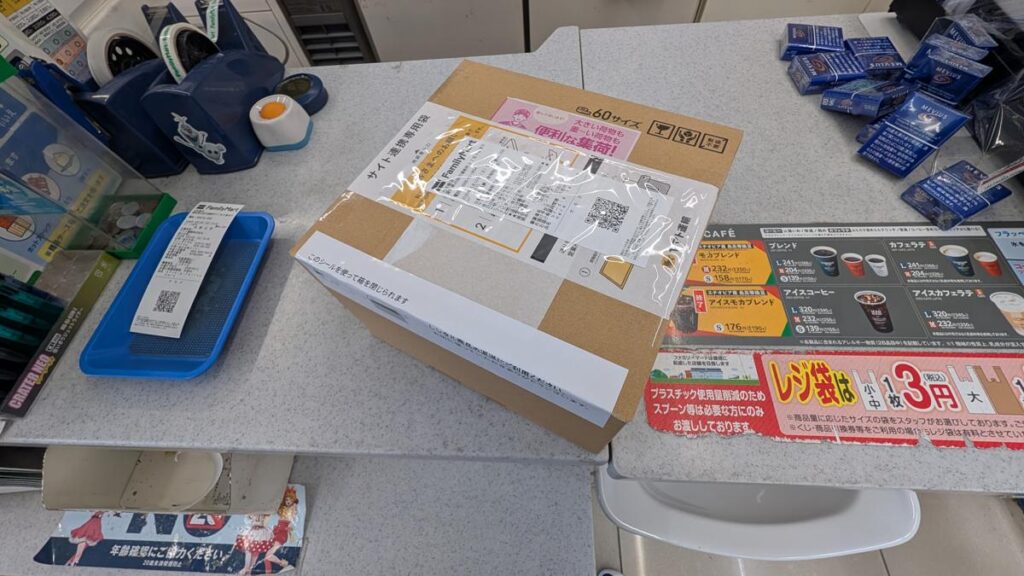 ファミリーマートのレジカウンターに置かれた、送り状を貼り付けた返却用の段ボール箱