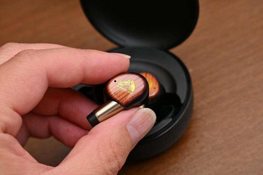 充電ケースから完全ワイヤレスイヤホン Victor WOOD master を取り出す手元のカット