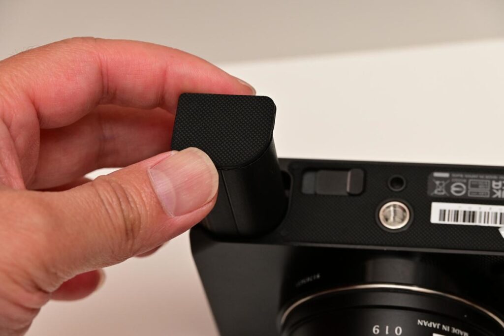 SIGMA bfにバッテリーを挿入する瞬間の指先の様子