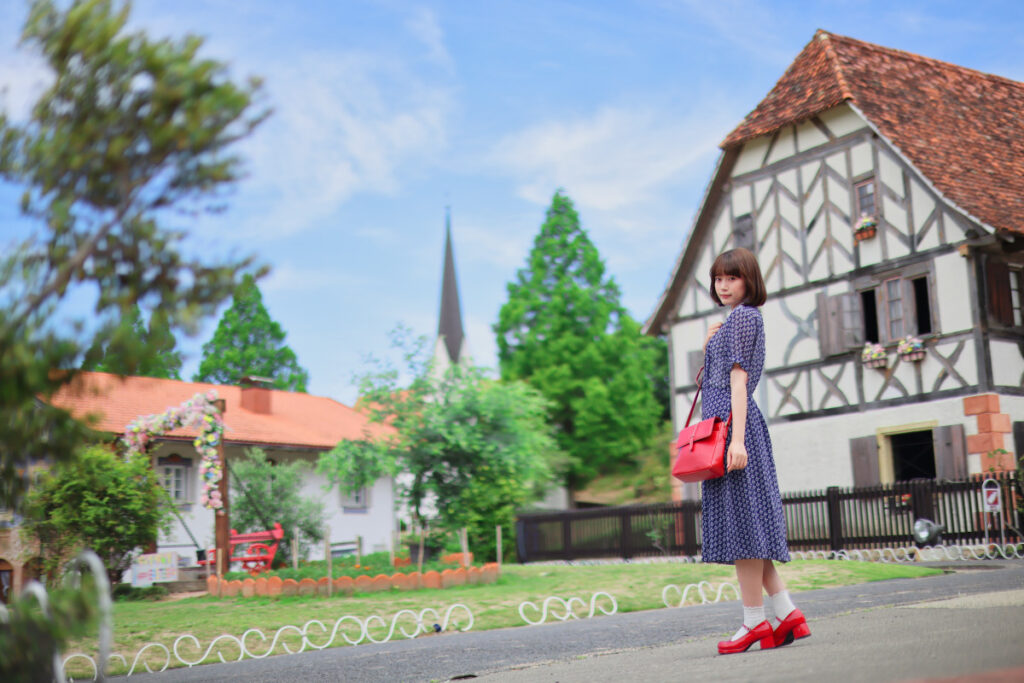 バイエルンの街並みを背景に、RF45mm F1.2で撮影したカワイマドカさんの全身ポートレート