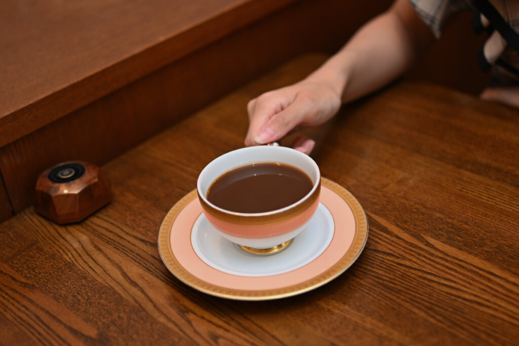 コーヒーカップに手を添える菜穂さんの写真