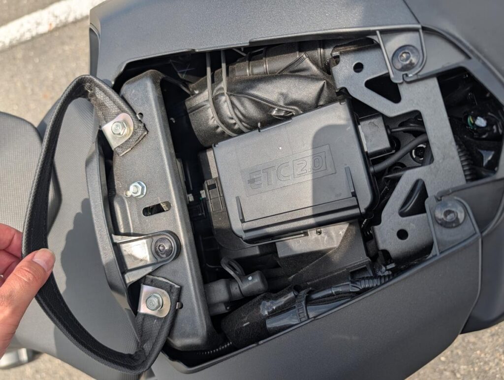 純正ETC2.0車載器と工具で満たされたタイトなシート下収納スペース