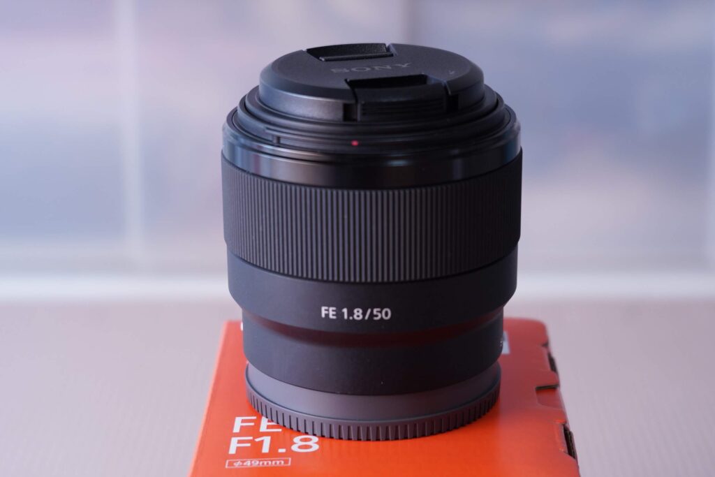 レンズ箱の上に置かれた、ソニーのフルサイズ用単焦点レンズ FE 50mm F1.8の全体像。