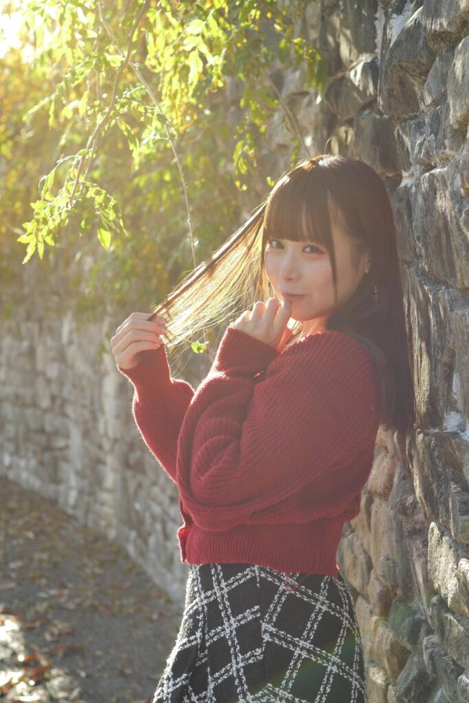 F2.8に絞って撮影した作例。美しいフレアが入り込む光の中で壁に寄りかかる鹿乃ばんびさんのポートレート。