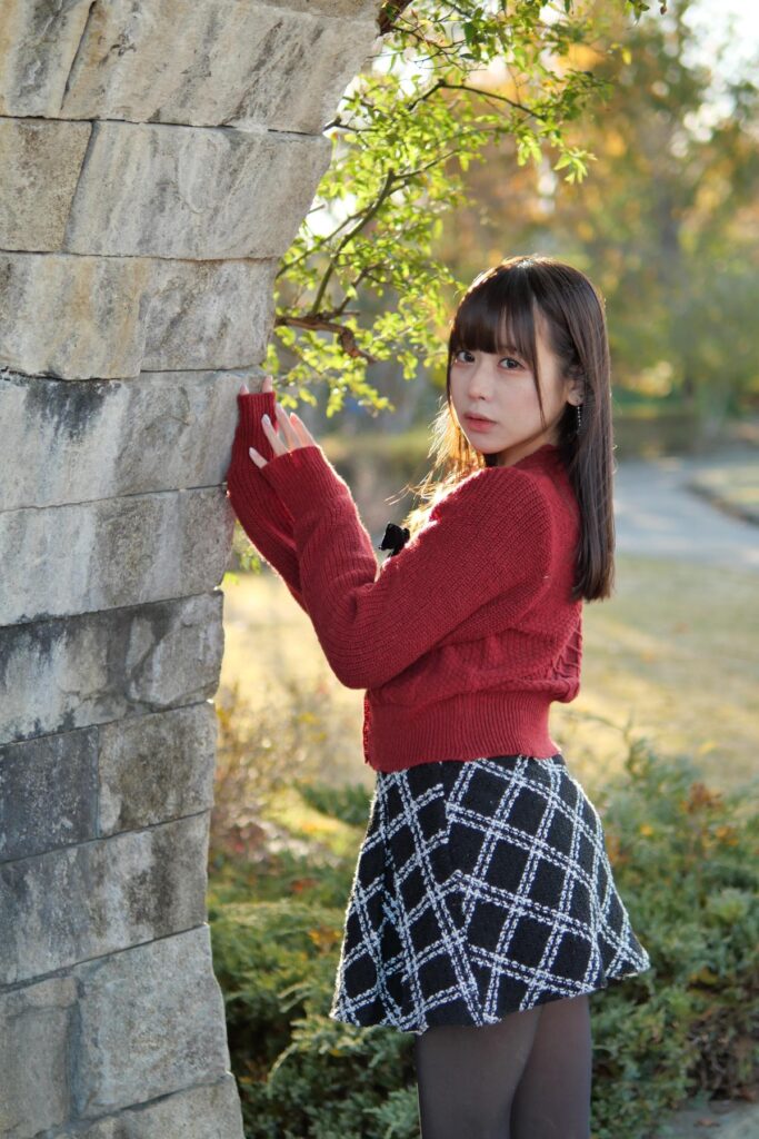 石壁に両手を添えて、振り返るようなポーズでこちらを真っ直ぐ見つめる鹿乃ばんびさん。