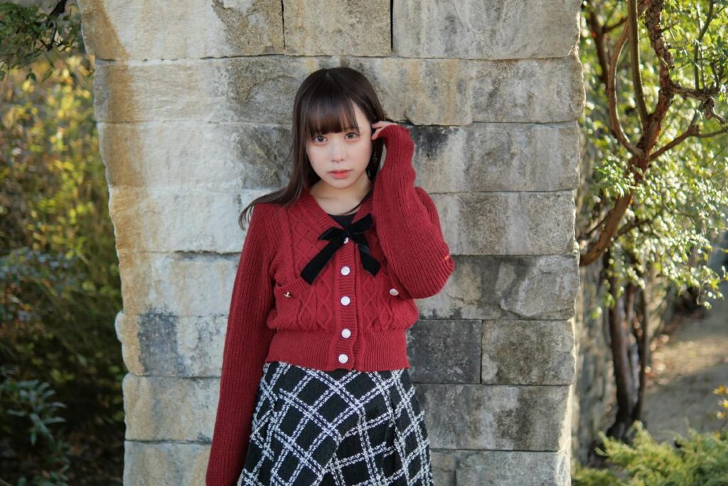 石壁に両手を添えて、振り返るようなポーズでこちらを真っ直ぐ見つめる鹿乃ばんびさん。
