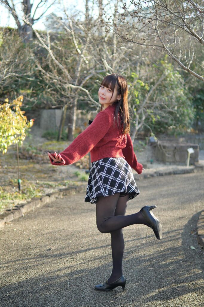 屋外の通路で、片足をスッと前に出してポーズをとる鹿乃ばんびさんの全身ポートレート。