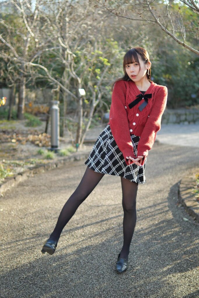 通路の真ん中で、片足を上げて楽しそうにポージングをする鹿乃ばんびさんの全身カット。