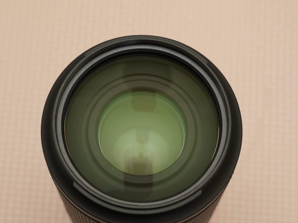 フィルター径Φ67mmのクリアな光学ガラスが見えるTAMRON 70-180mm F/2.8 Di III VXDのレンズ正面