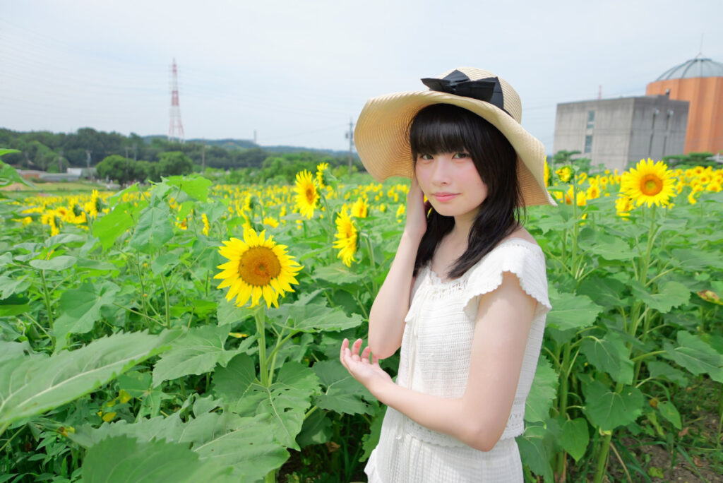 24mm広角端:ひまわり畑の一本道を歩く白いワンピース姿の女性モデル