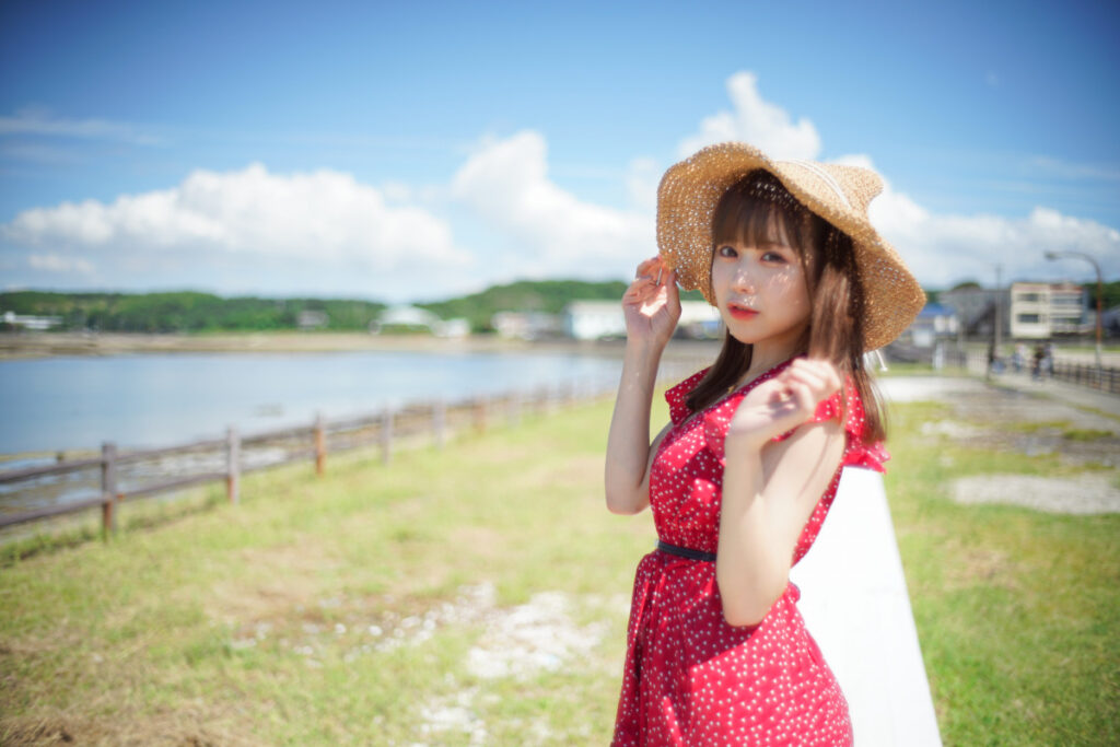 夏の強い光の中で、カメラを真っ直ぐに見つめる鹿乃ばんびさんの横顔クローズアップ