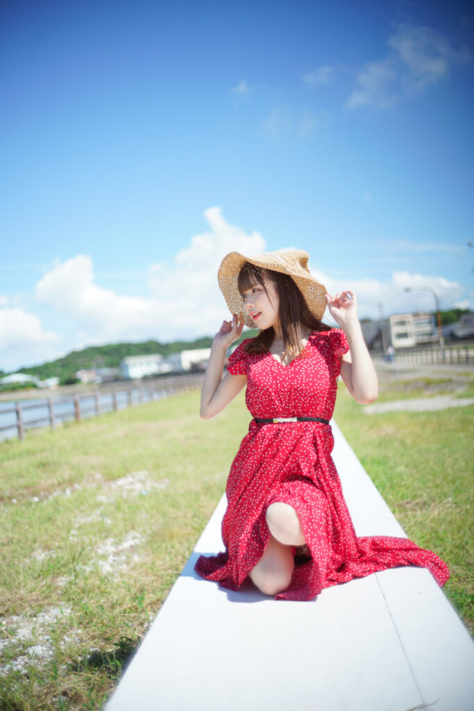 白いオブジェの上に座り、頬に手を当てて微笑む麦わら帽子の鹿乃ばんびさん