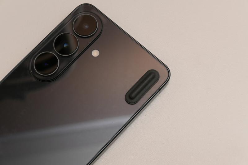Galaxy S26の背面カメラレンズのすぐ横にThinkPad用互換ラバーフットを貼り付け、机に置いた時のカタカタ感を解消したDIY写真
