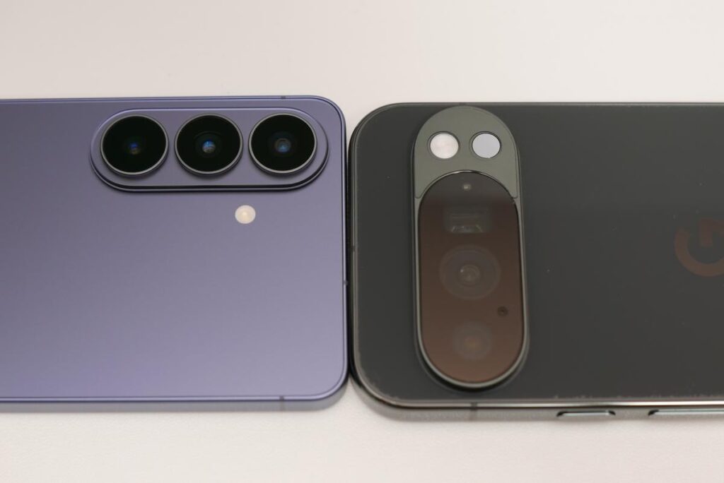 Google Pixel 10 Proの黒い背面とSamsung Galaxy S26の紫色の背面をフラットに並べた全体外観