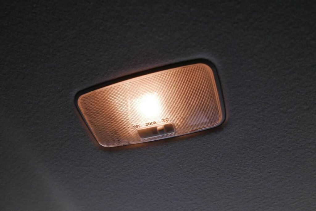 透明カバーを外して中央の樽型純正電球が見えるようになったリヤルームランプ
