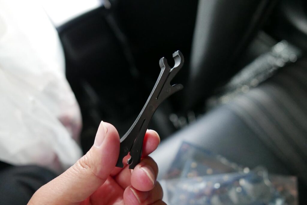 指で持ったシェアスタイル付属の黒いプラスチック製電球取り外し治具