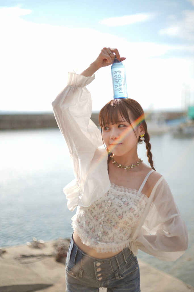レンズに入り込んだ光によって美しい光跡が描かれた、笑顔を見せる鹿乃ばんびさんのクローズアップ