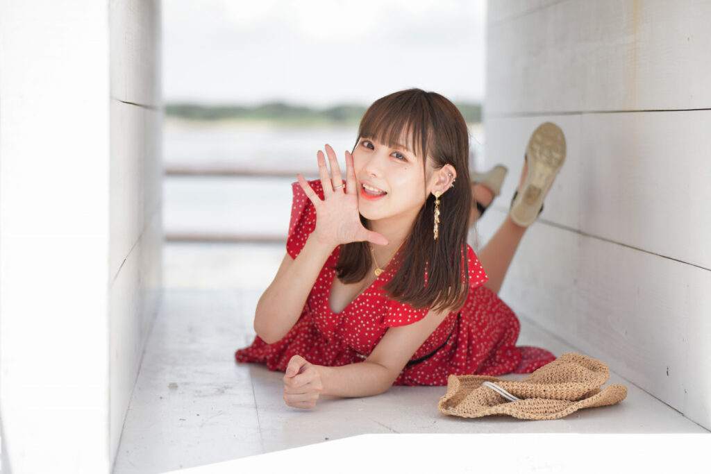 白い箱の中で楽しそうに寝そべり、カメラに向かって手を振る鹿乃ばんびさんの中望遠ポートレート