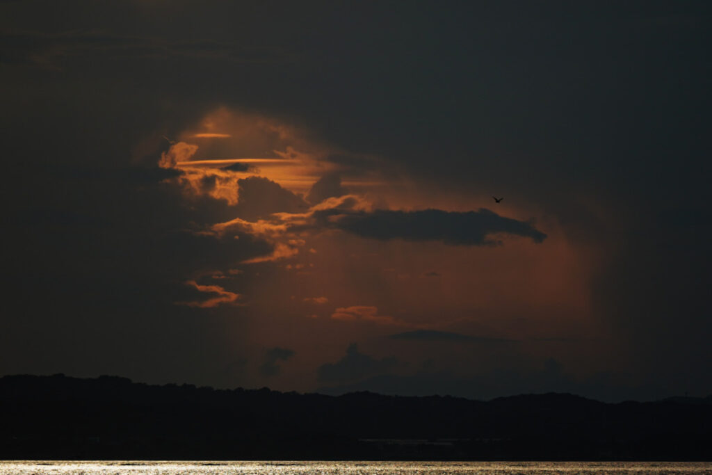 夕暮れの雲の隙間から、黄金色の美しい夕日が漏れ出す佐久島のドラマチックな空模様