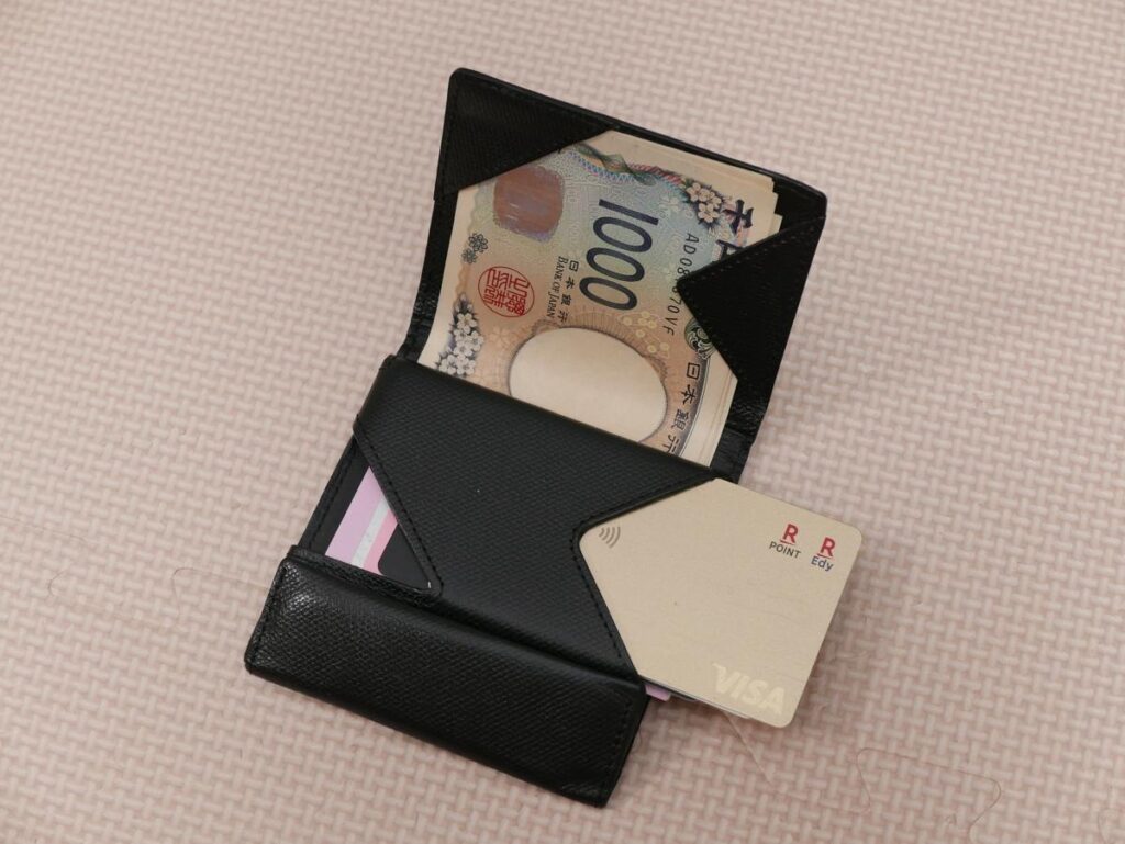薄い財布 abrAsusを開いてお札とカードを収納している様子