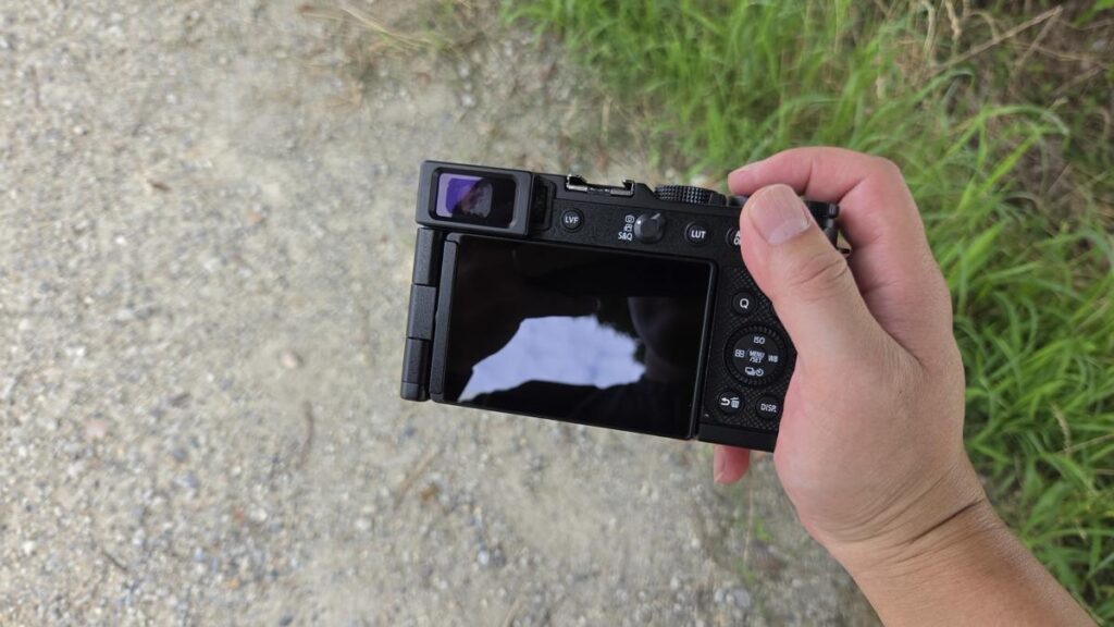 LUMIX L10を右手で片手持ちしている屋外での様子