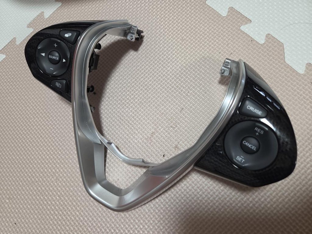 ステアリングから取り外した左右のスイッチユニットとシルバーベゼル