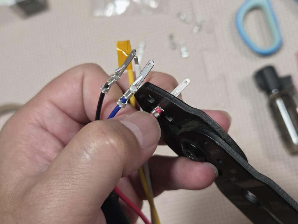 電工ペンチを使ってリレー配線に110型カプラー用オスターミナルを圧着する様子